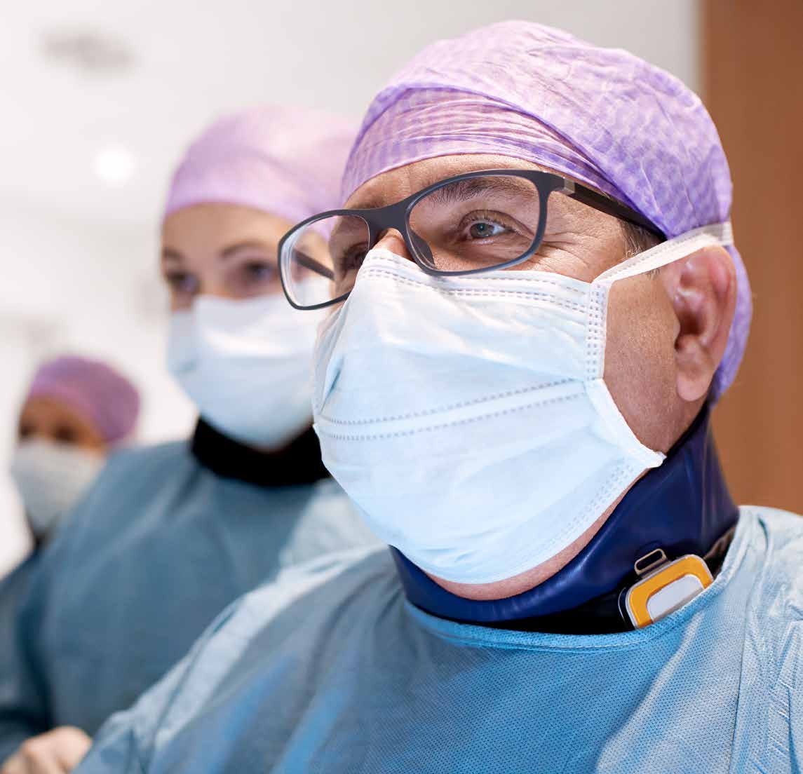 Interventional clinicians wearing protective equipment and a personal dose monitor